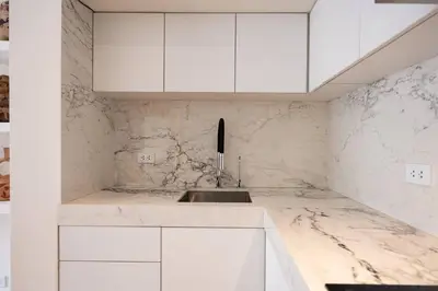 a white kitchen with a sink and white cabinets at * Casma Residence * Private Terrace & Grill & HVAC in Lima