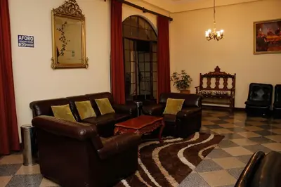 a living room with leather chairs and a table at Hotel Presidente Huancavelica - Asociado Casa Andina in Huancavelica