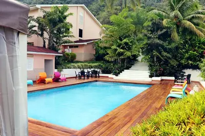 a swimming pool with a wooden deck and a house at Hotel Presidente Selva in La Merced