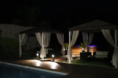 a pool with two umbrellas and a table and chairs at night at Hotel Presidente Selva in La Merced