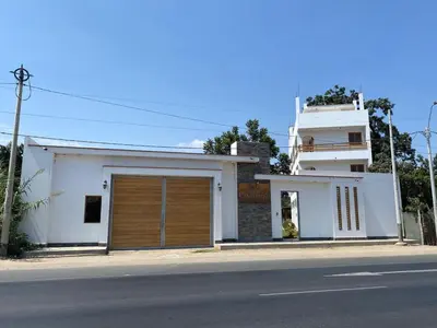 a white house with a garage on the side of a street at HOTEL HACIENDA SUBTANJALLA CASABLANCA in Ica