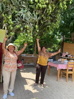 two women are holding up a bunch of fruit at HOTEL HACIENDA SUBTANJALLA CASABLANCA in Ica