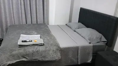 a bed with a towel and a remote control on it at Residencial Salamanca in Lima