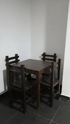 a wooden table with two chairs around it at Residencial Salamanca in Lima