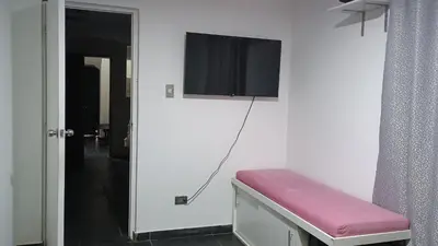a room with a tv on a wall with a purple bench at Residencial Salamanca in Lima