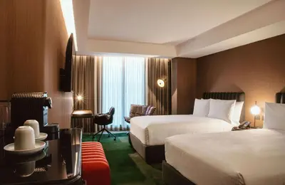 a hotel room with two beds and a chair at Doubletree By Hilton Lima San Isidro in Lima