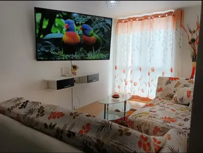 a living room with a couch and a tv on the wall at lindo departamento Frente al mar in Lima