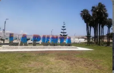 a park with a bench in the grass at lindo departamento Frente al mar in Lima