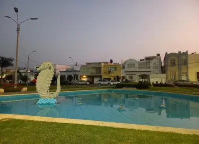 a large swimming pool with a statue next to it at lindo departamento Frente al mar in Lima