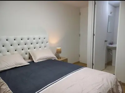 a bedroom with a large bed with a large headboard at lindo departamento Frente al mar in Lima