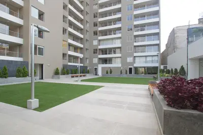 an apartment courtyard with a bench and grass at Apartment near to MIRAFLORES, BEACHES & REBAGLIATI HOSPITAL ! Panoramic View,Pool, Gym,Private Park in LINCE in Lima