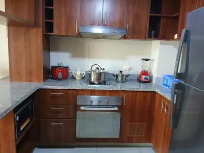 a kitchen with wooden cabinets and a stove with pots and pans at Apartment near to MIRAFLORES, BEACHES & REBAGLIATI HOSPITAL ! Panoramic View,Pool, Gym,Private Park in LINCE in Lima