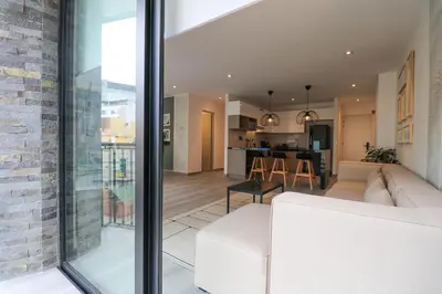 a living room and kitchen with a white couch at Caster by Wynwood House in Lima
