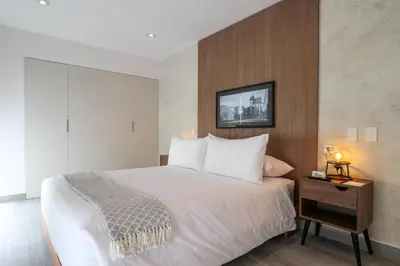 a bedroom with a large white bed and a night stand at Caster by Wynwood House in Lima