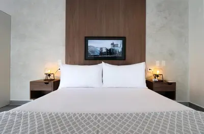 a bedroom with a large white bed with two night stands at Caster by Wynwood House in Lima
