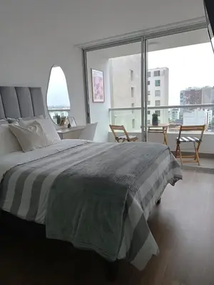 a bedroom with a large bed and a large window at Vive y trabaja con estilo en San Miguel, moderno departamento de 2 dorms con balcon in Lima