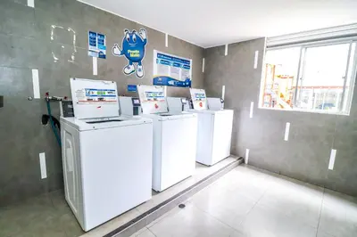 a laundry room with four white washer and dryers at Vive y trabaja con estilo en San Miguel, moderno departamento de 2 dorms con balcon in Lima