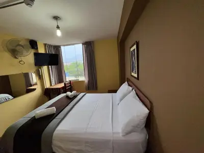 a hotel room with a large bed with a window at La Posada del Rey - Lima Airport Hostel in Lima