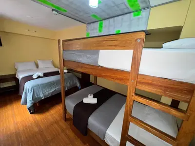 two bunk beds in a room with green lights at La Posada del Rey - Lima Airport Hostel in Lima