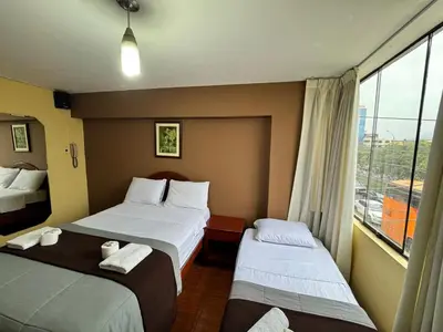 a hotel room with two beds and a window at La Posada del Rey - Lima Airport Hostel in Lima