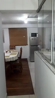 a small kitchen with a table and a refrigerator at Arcopata Apartamentos in Cusco
