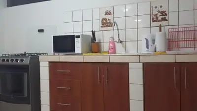 a kitchen with a counter with a stove and a microwave at Arcopata Apartamentos in Cusco