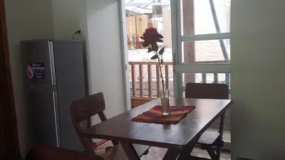 a table with a vase on top of it next to a refrigerator at Arcopata Apartamentos in Cusco