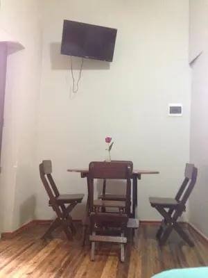 a dining room table with two chairs and a tv at Arcopata Apartamentos in Cusco