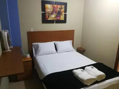 a bedroom with a bed with two towels on it at Hostal Aventura Total Perú_lunahuana in Lunahuaná