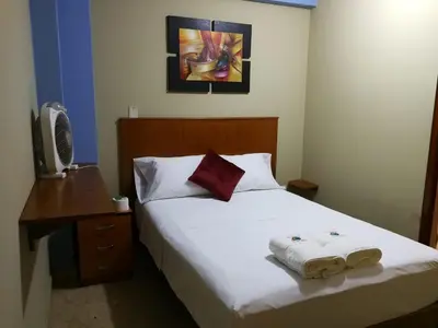 a bedroom with a bed with two towels on it at Hostal Aventura Total Perú_lunahuana in Lunahuaná