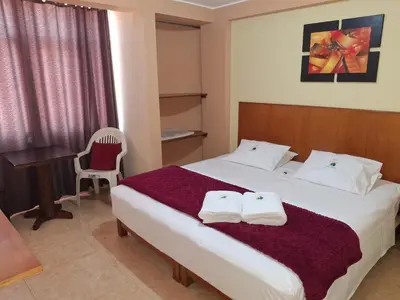 a bedroom with a bed with two towels on it at Hostal Aventura Total Perú_lunahuana in Lunahuaná