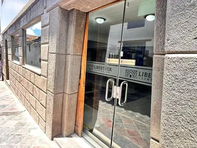 a glass door of a building with a sign in it at Libertrek Centro Inn in Cusco