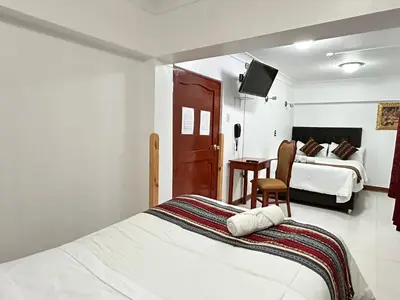 a hotel room with two beds and a television at Libertrek Centro Inn in Cusco