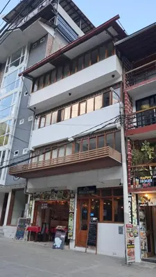 a tall building with a restaurant in front of it at Hotel Romero Machupicchu in Machu Picchu