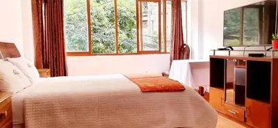 a bedroom with a bed and a large window at Hotel Romero Machupicchu in Machu Picchu