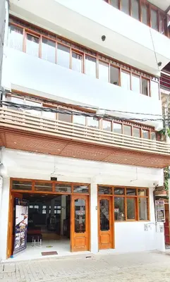 a white building with wooden doors and windows at Hotel Romero Machupicchu in Machu Picchu