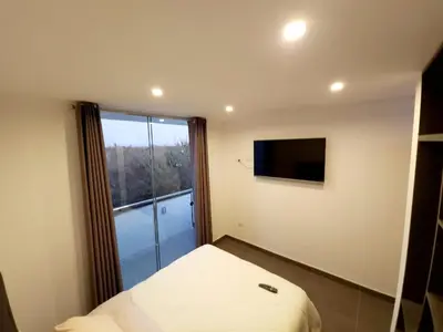 a small bedroom with a bed and a window at Acogedor departamento en Huacachina in Ica