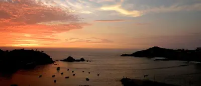 a group of boats in the water at sunset at Posada del Mirador Italyan Villa in San Bartolo