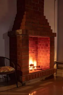 a brick fireplace with a fire in it at Amplia Casa de Campo con Piscina en Cieneguilla in Cieneguilla