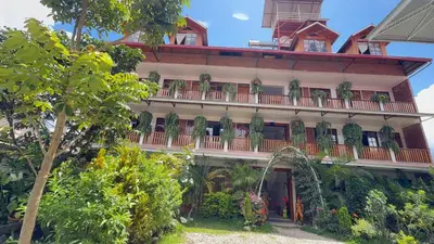 a building with a balcony with plants on it at Hospedaje Oxa Paraíso in Oxapampa