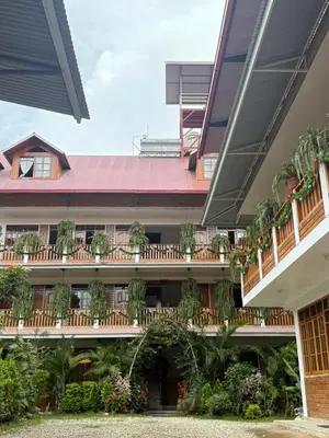 an external view of a building with potted plants at Hospedaje Oxa Paraíso in Oxapampa