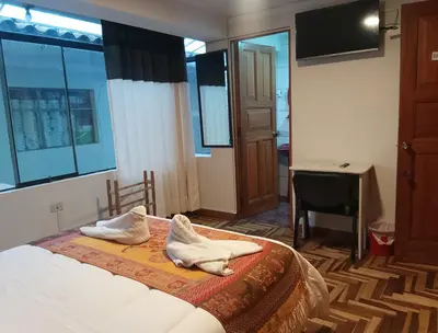 a bedroom with a bed with towels on it at Hostel Tupac Yupanqui House in Cusco