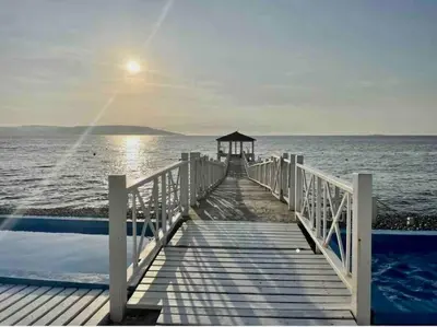 a wooden pier with a gazebo on the water at Departamento Paracas vista al mar in Paracas