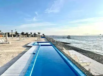 a beach with two swimming pools next to the water at Departamento Paracas vista al mar in Paracas