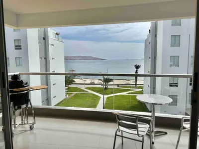 a balcony with a view of the ocean from a building at Departamento Paracas vista al mar in Paracas
