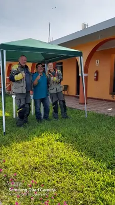 a group of men standing under a green canopy at BUENDIA HOTEL in Pueblo Viejo