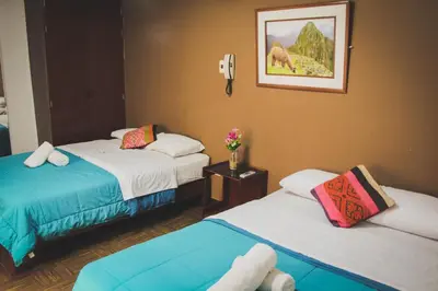 a room with two beds and a picture on the wall at Tupac Lima Airport in Lima