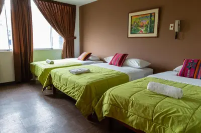 a hotel room with two beds with green sheets at Tupac Lima Airport in Lima