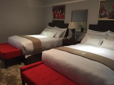a hotel room with two beds and a red bench at Atiq Boutique Hotel in Cusco