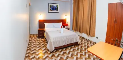 a hotel room with a bed with a vase on it at Hotel Mayros in Satipo